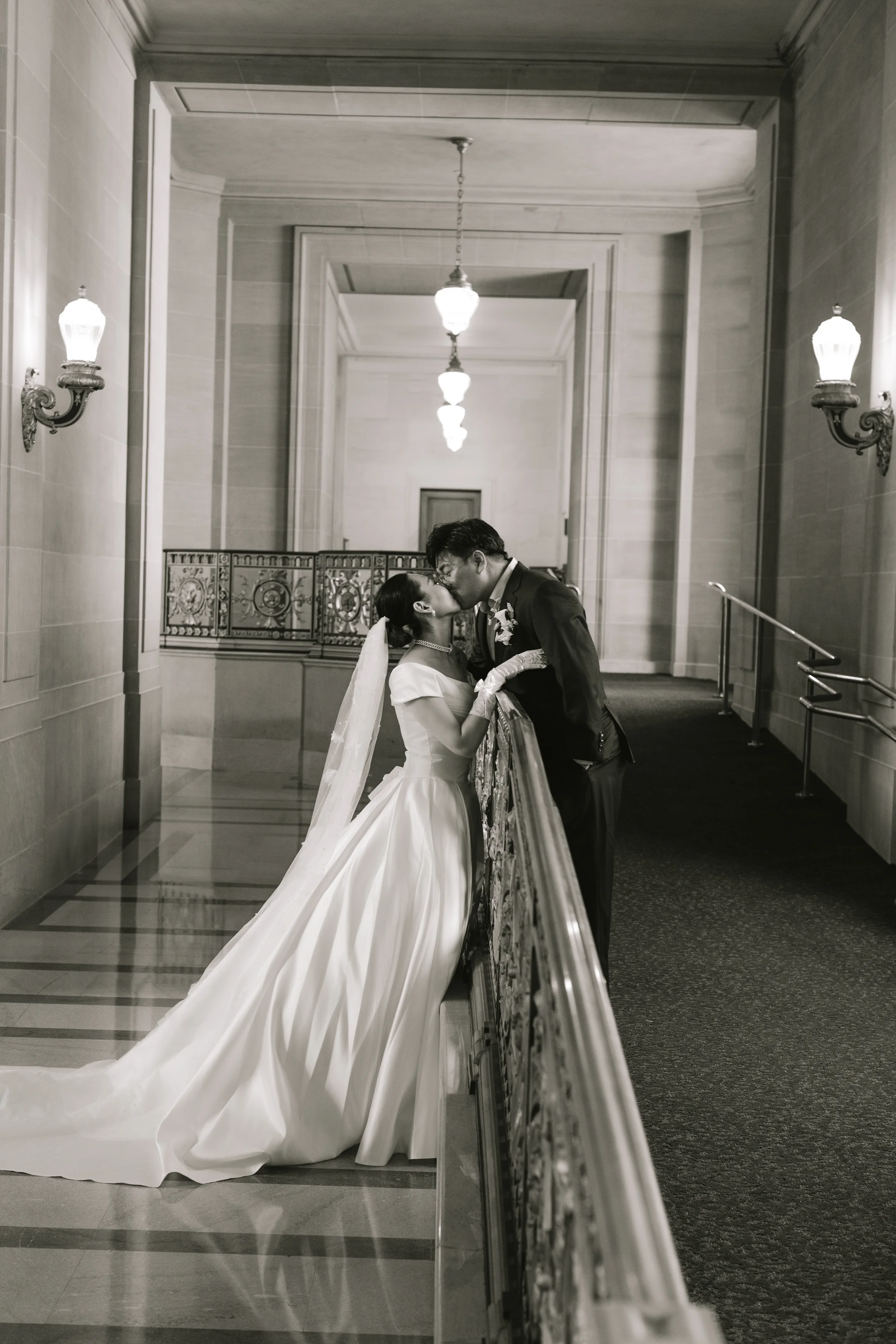Black-and-white photo of the couple embracing on the staircase