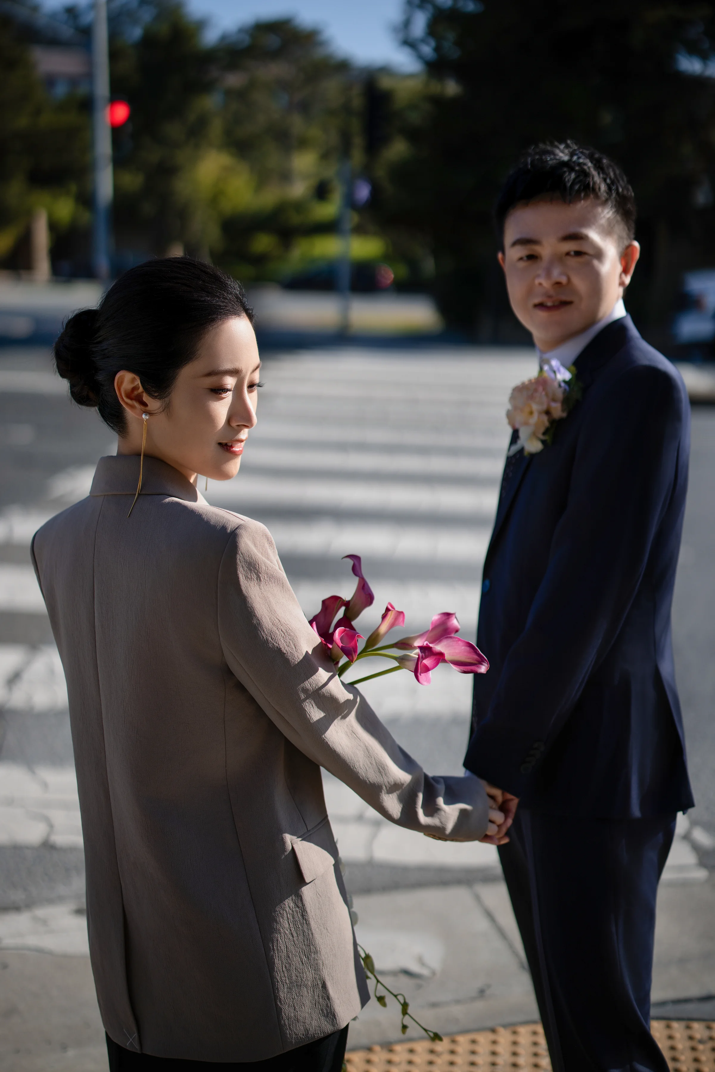 Bride adjusting the groom's tie at a street crosswalk