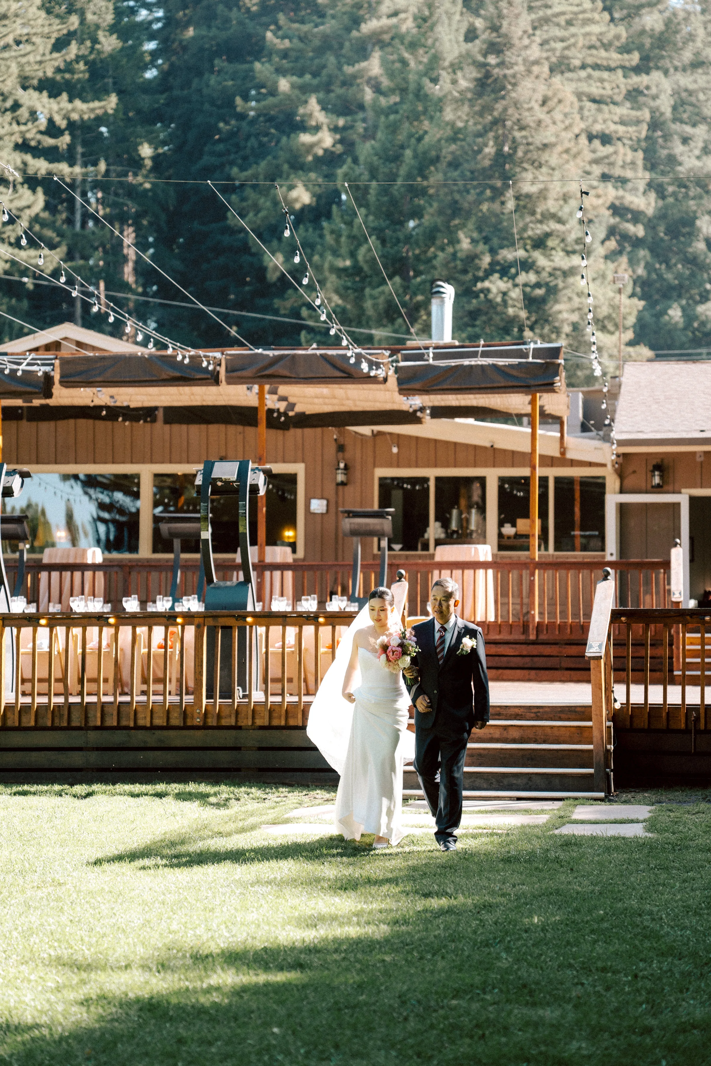 Couple crossing a lawn in front of a wooden lodge building