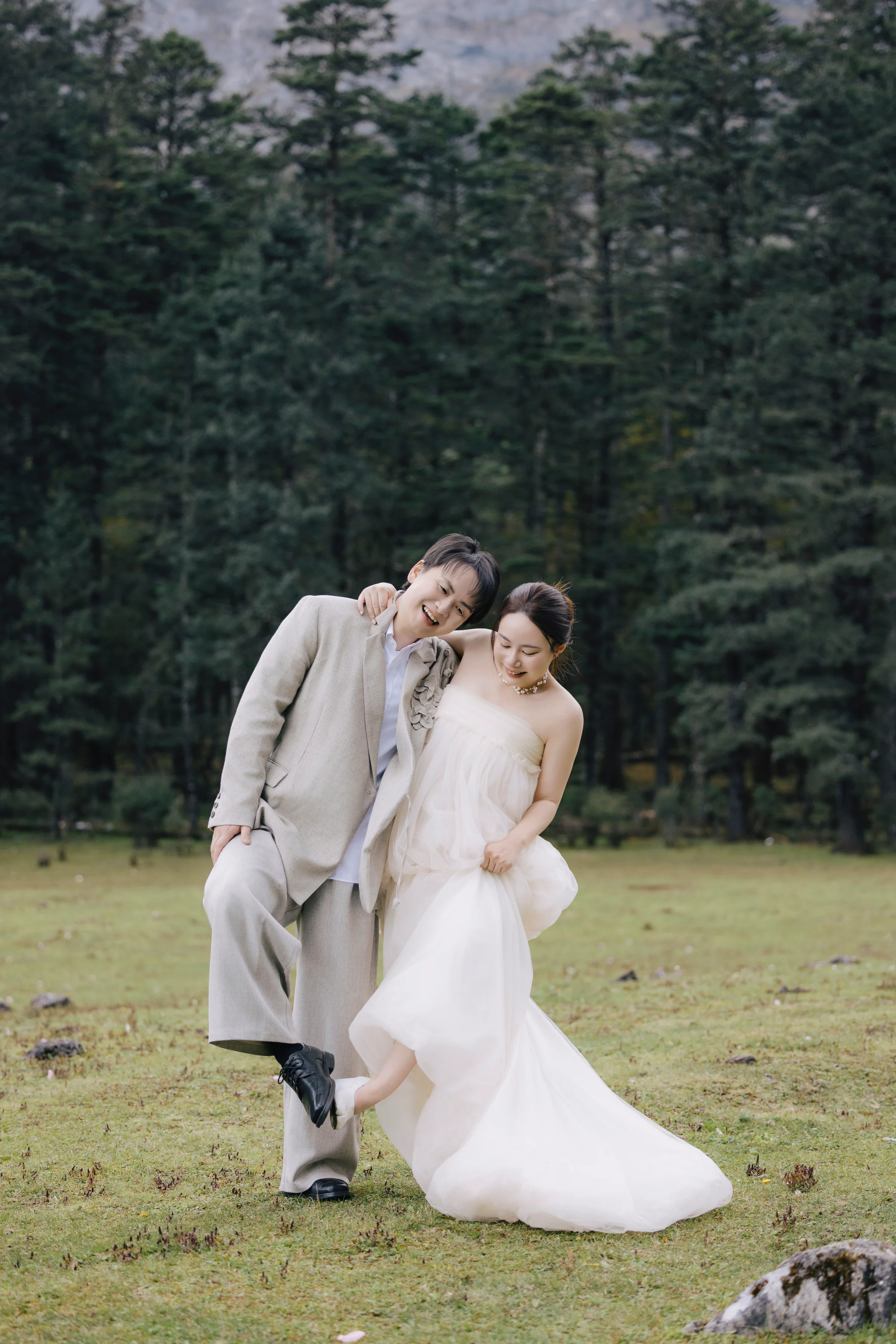 Couple embracing in an alpine meadow ringed by pine forest
