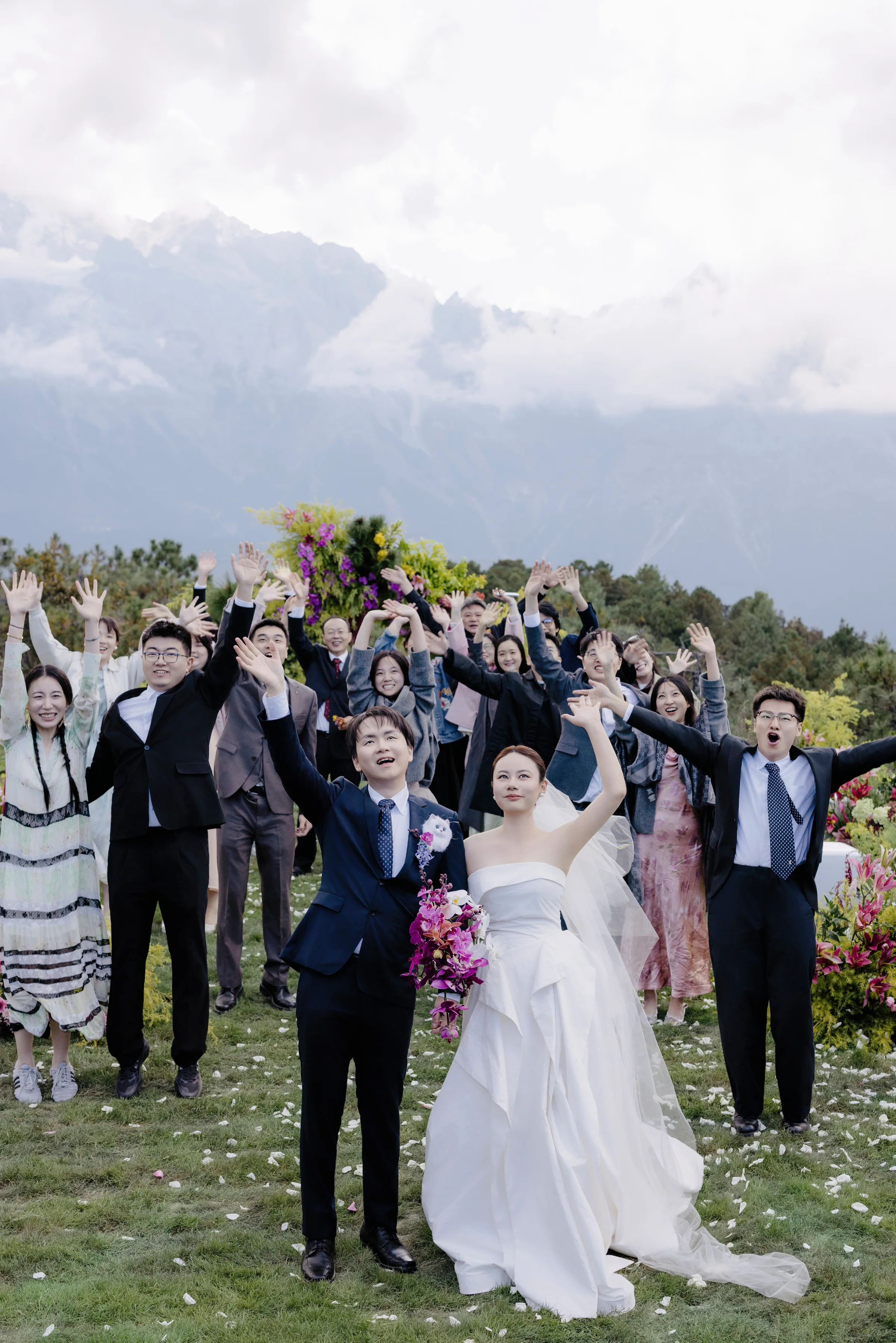 Wedding party celebrating around the bride and her bouquet on the lawn