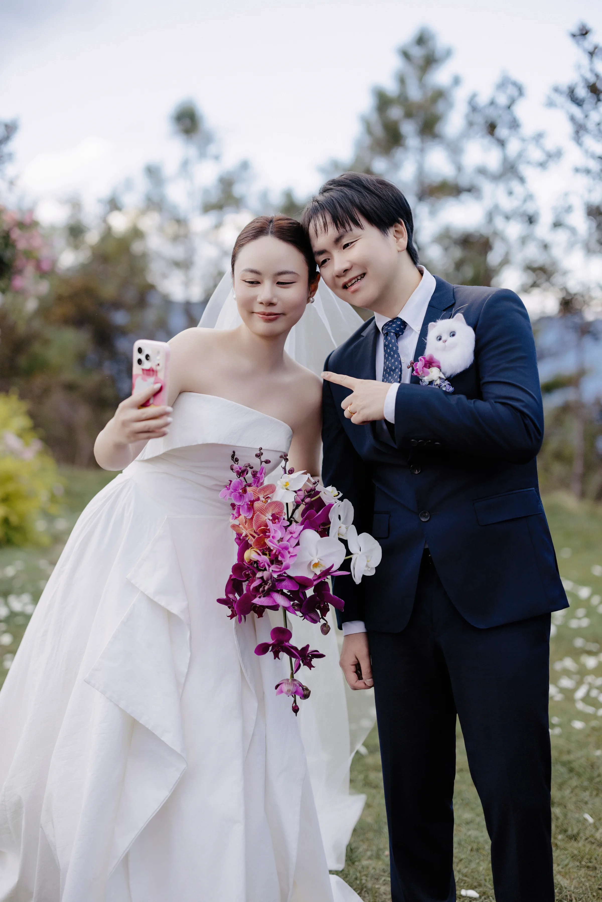 Couple taking a selfie, the bride holding a purple orchid bouquet