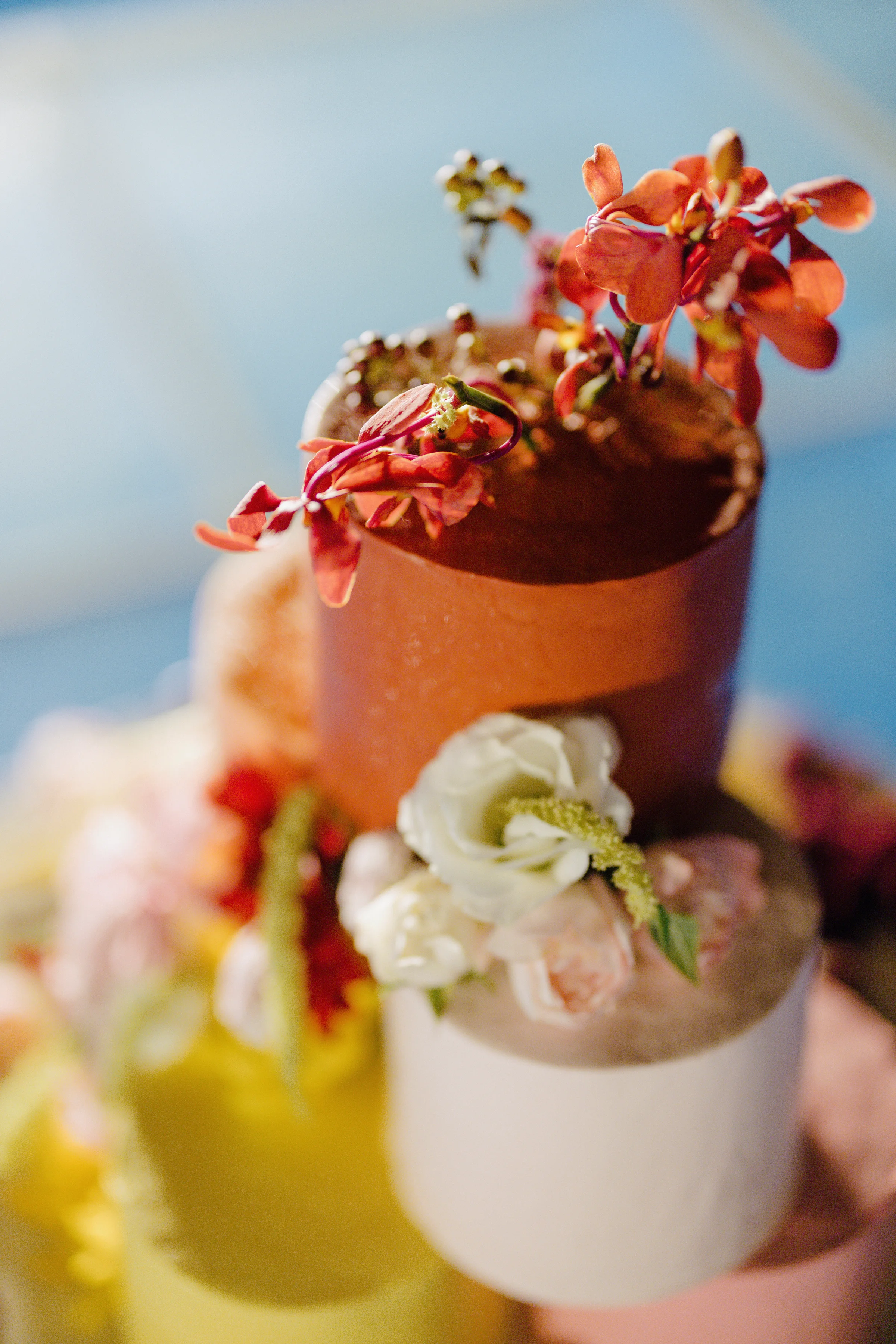 Close-up of the wedding cake topped with a terracotta pot of flowers