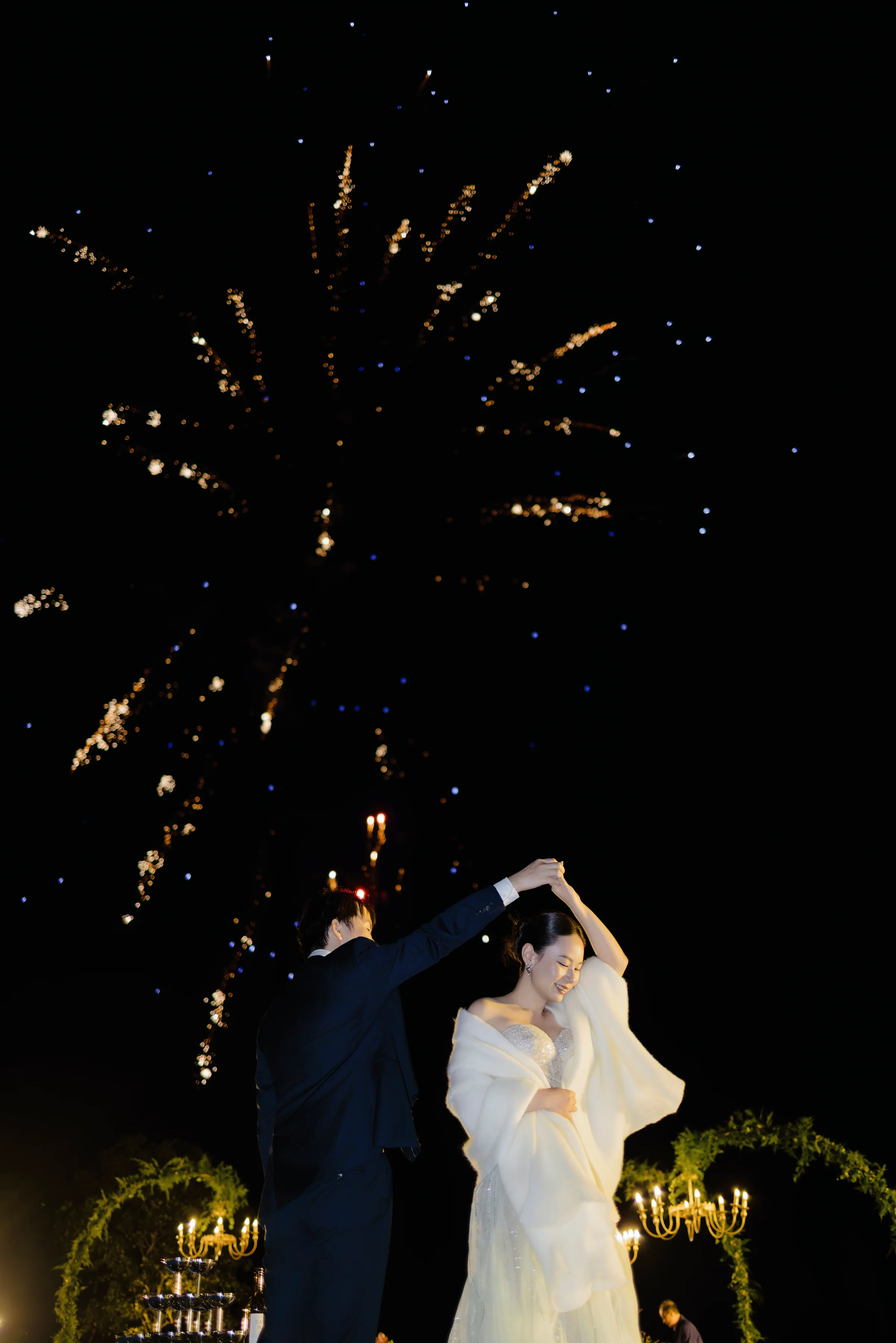 Couple dancing beneath fireworks in the night