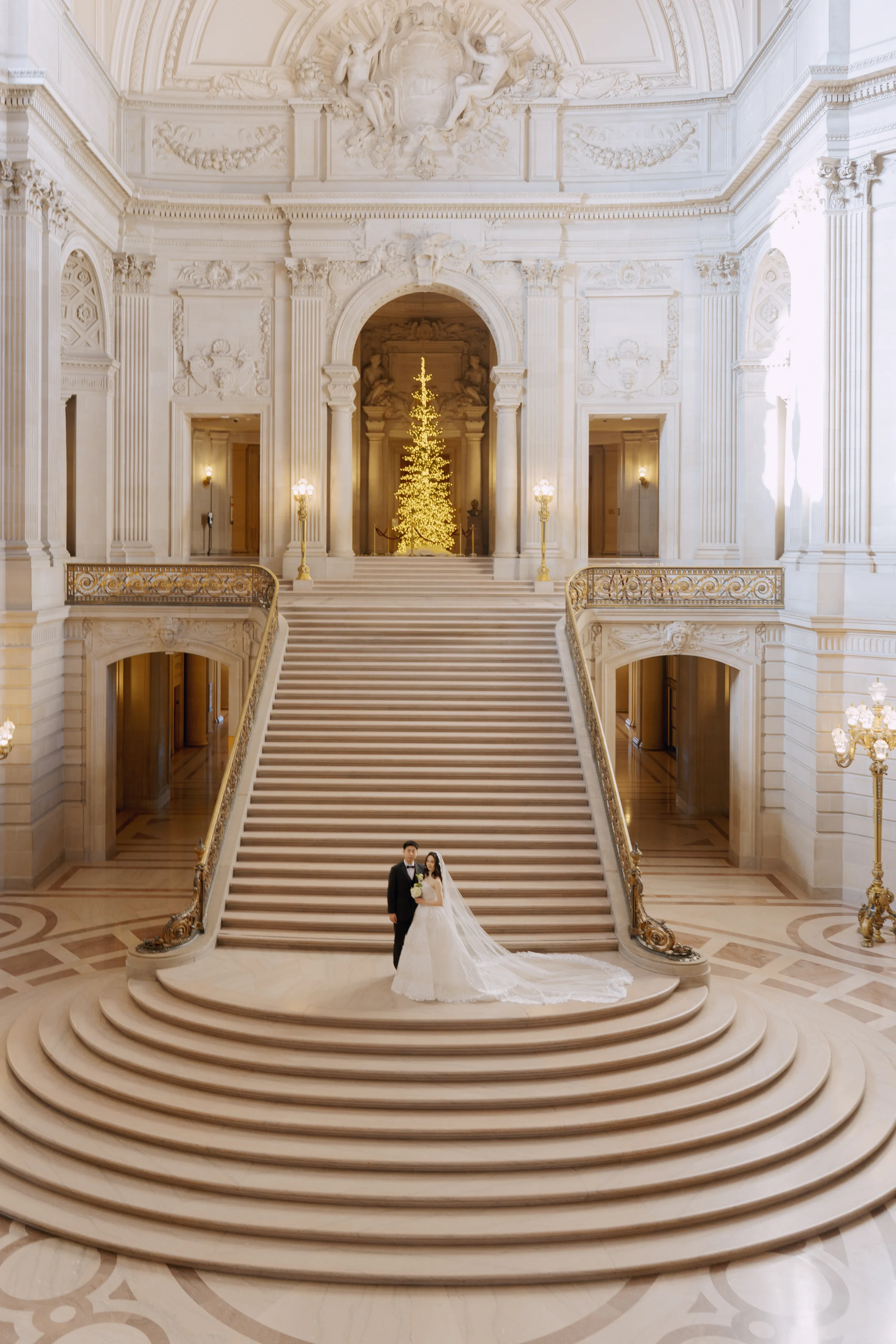 Couple small against the sweeping marble staircase and rotunda