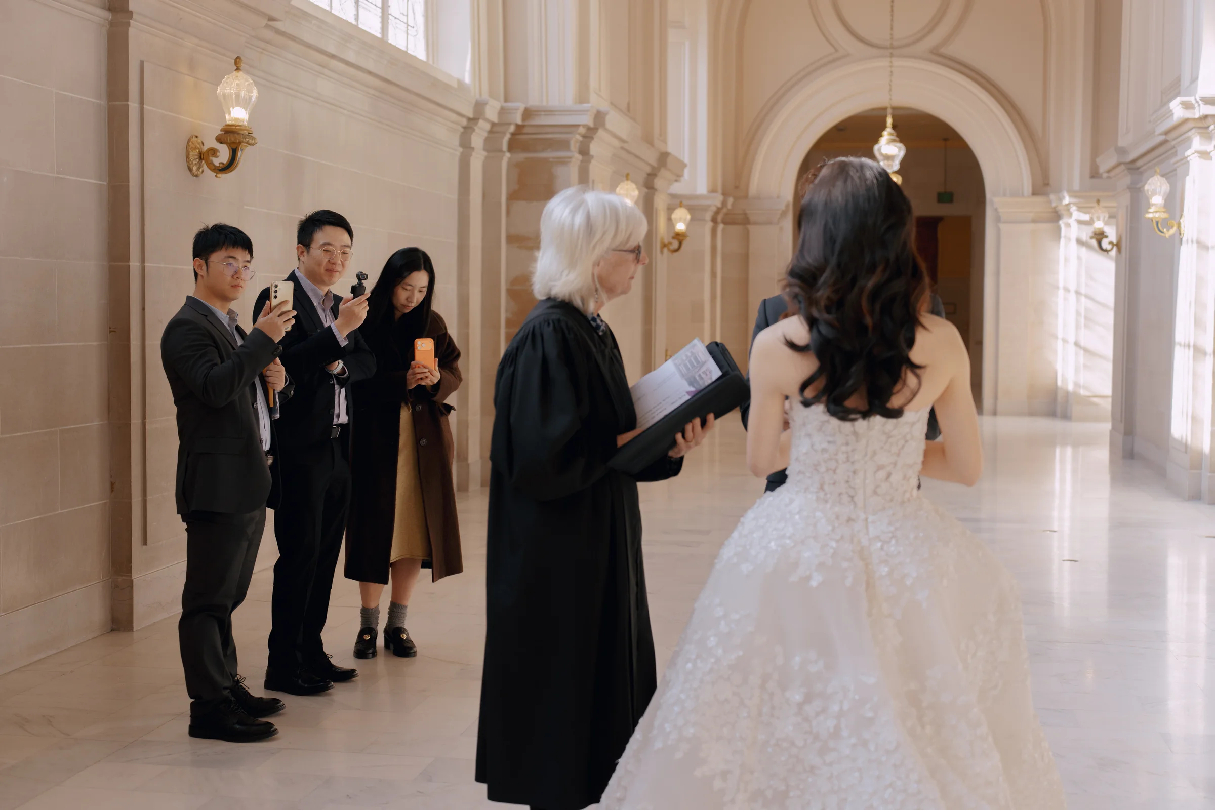 Bride in a beaded ball gown before the officiant during a San Francisco City Hall ceremony